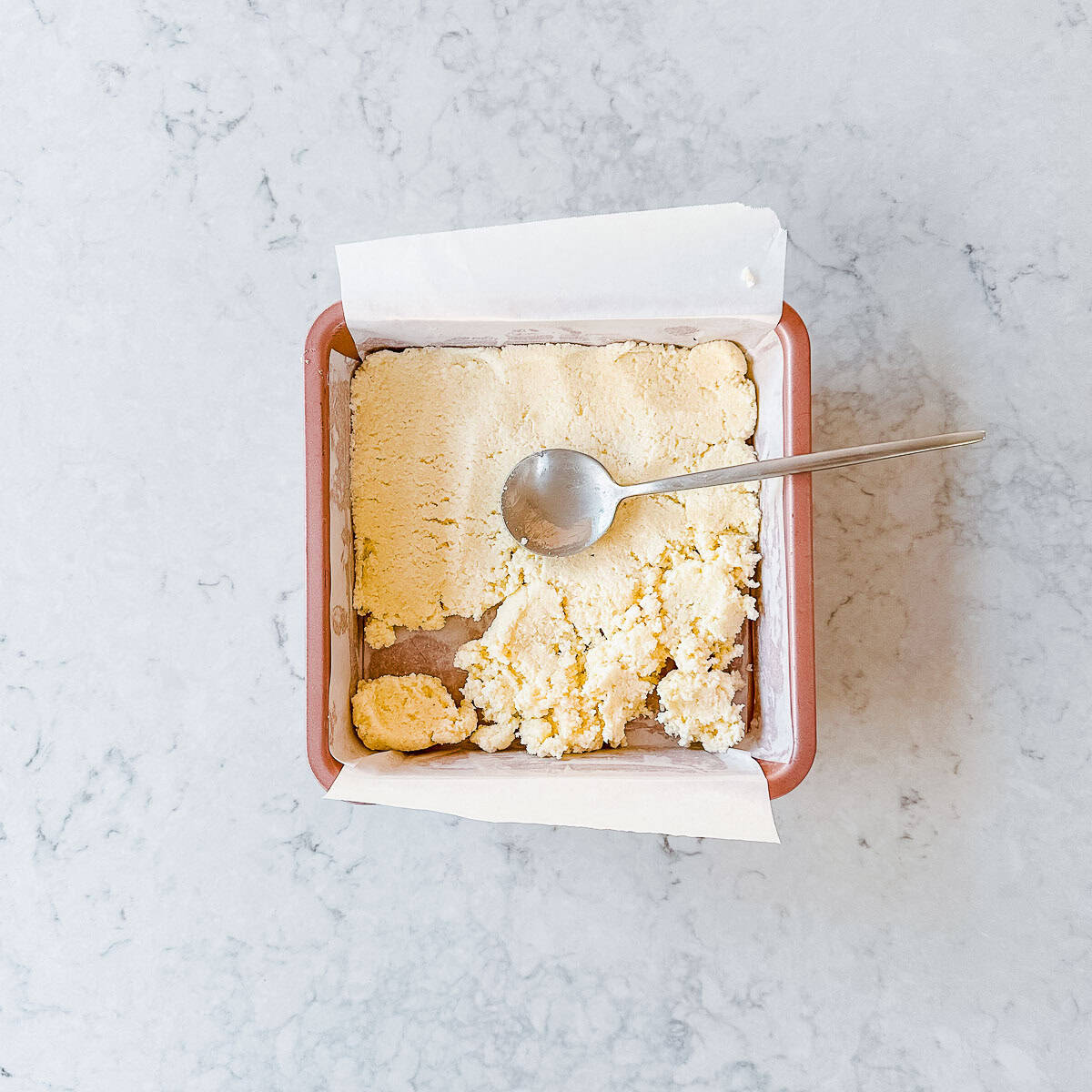 white Coconut ice in a pink square baking tin.