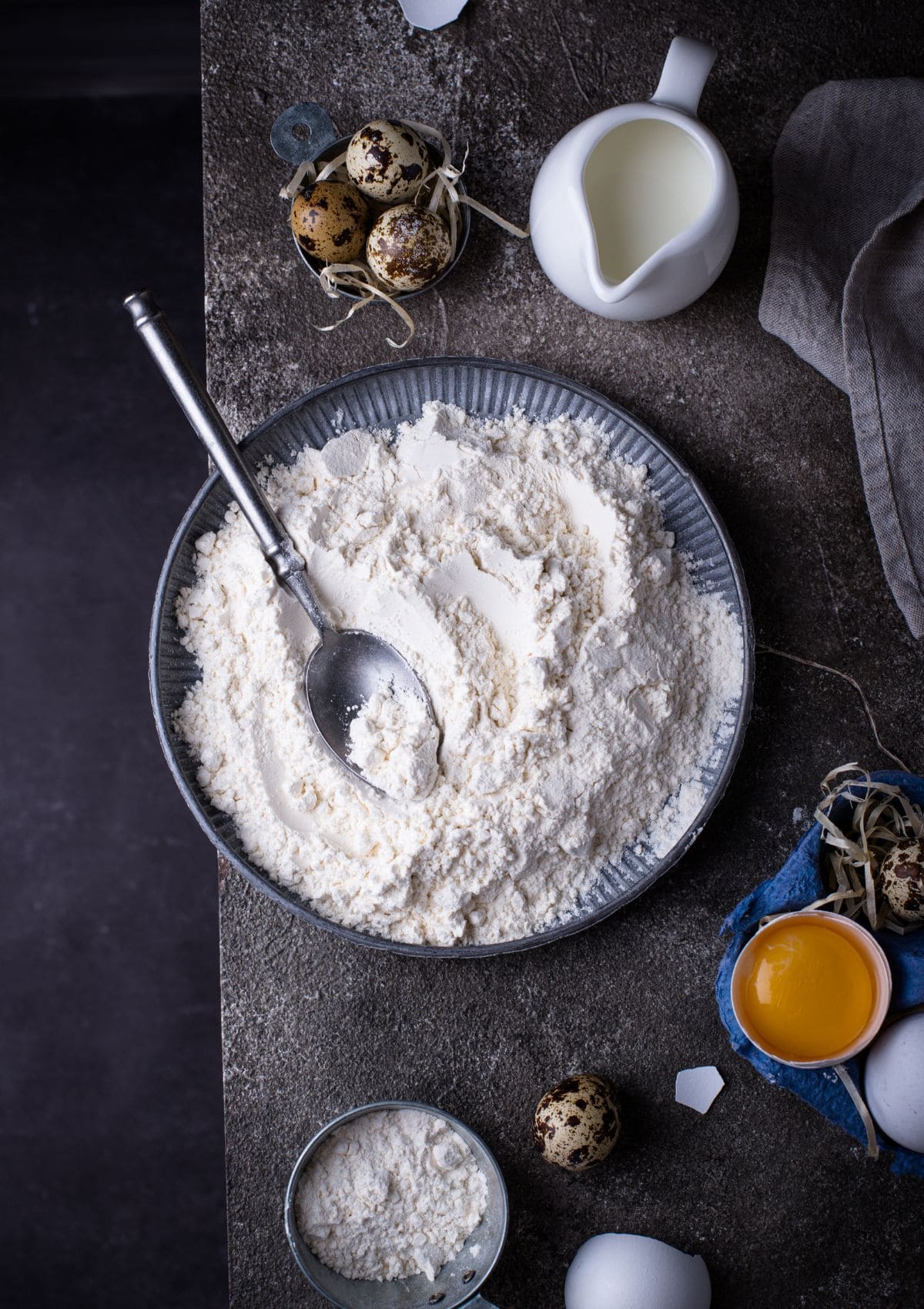 A bowl of self raising flour on a black background.