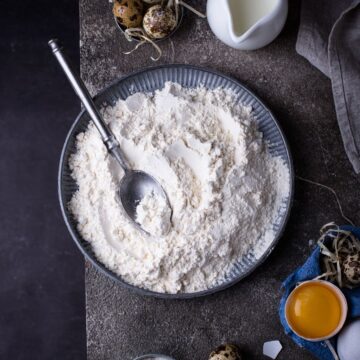 A bowl of flour on a dark background.