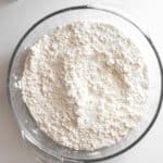 A glass bowl filled with white flour.