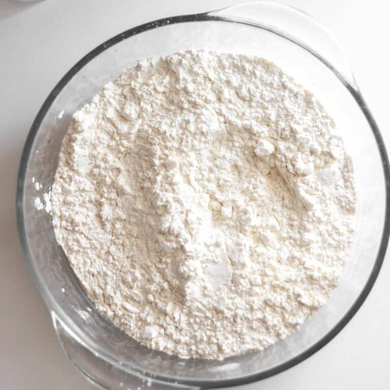 A glass bowl filled with white flour.